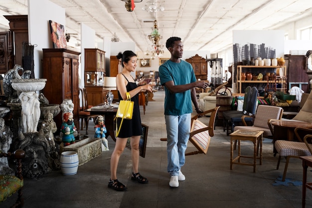 Full shot people with furniture at thrift shop