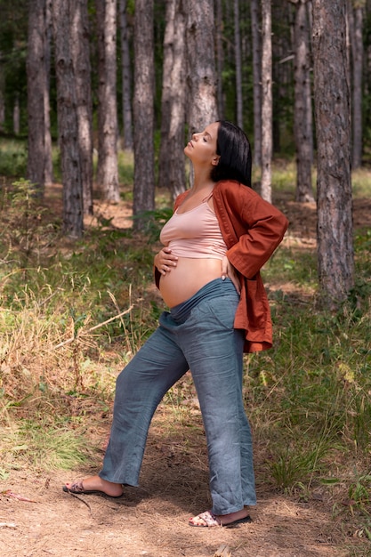 Foto donna incinta a tutto campo in natura