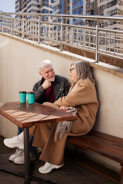 Photo full shot senior couple with coffee cups