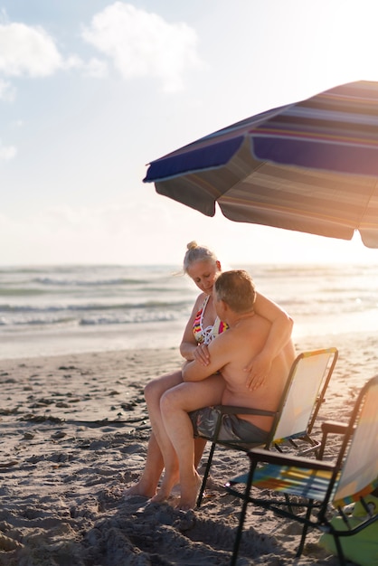 Foto full shot senior paar zittend op het strand