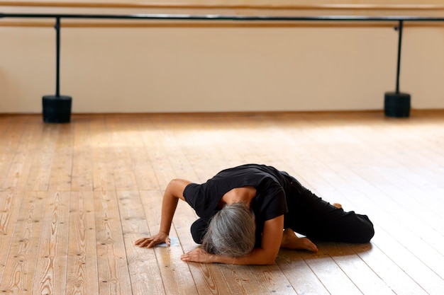 Foto donna maggiore del colpo pieno che balla nello studio