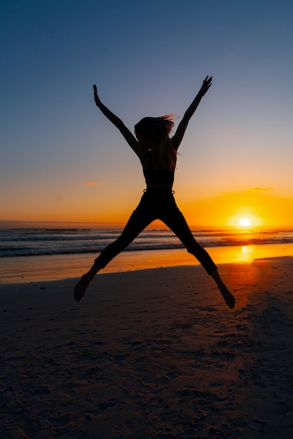 Full shot  silhouette jumping at sunset