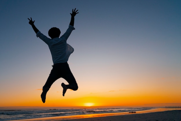 Photo full shot  silhouette jumping at sunset