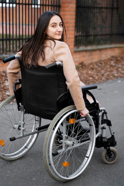 Full shot smiley disabled woman in wheelchair