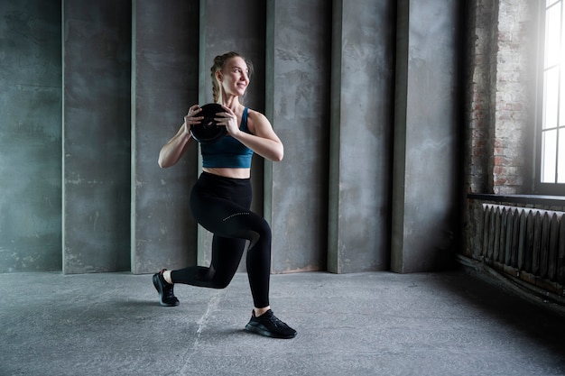 Foto full shot smiley fit vrouw die binnenshuis traint