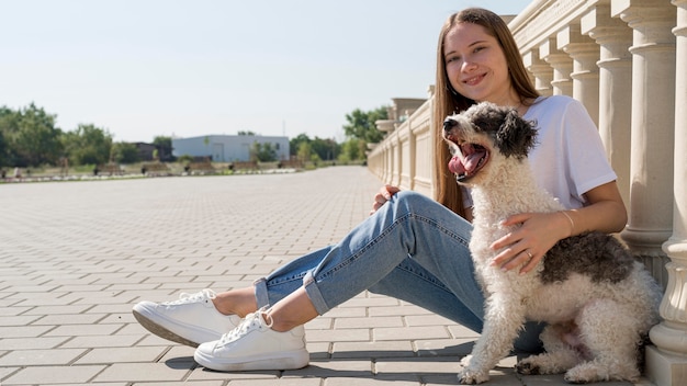 かわいい犬を抱いたフルショットスマイリーガール