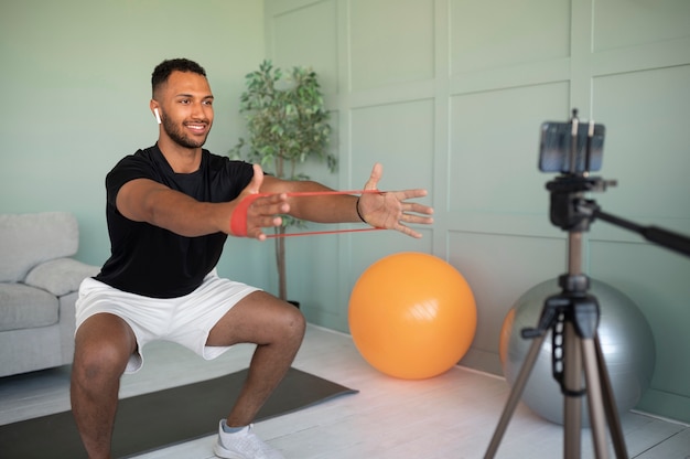 Full shot smiley man exercising at home