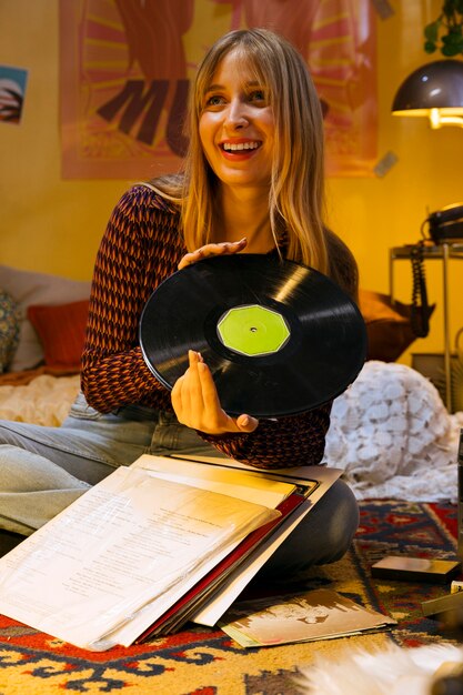 Foto adolescente sorridente a tutto campo con disco in vinile