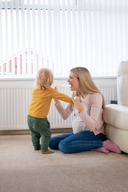 写真 フルショットスマイリー女性と自宅で子供