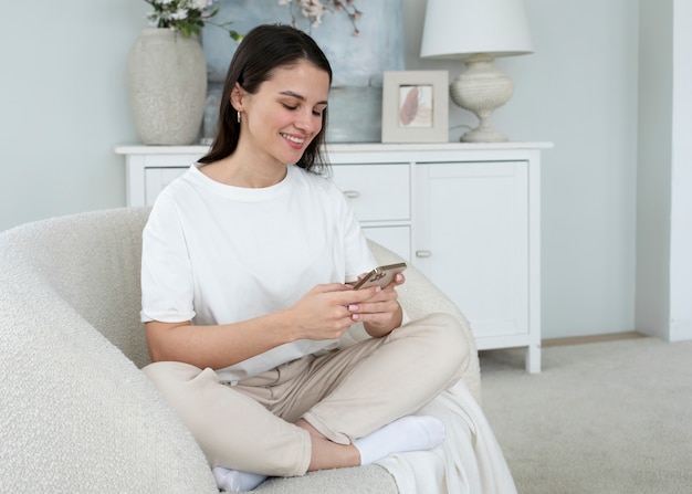 Photo full shot smiley woman holding smartphone