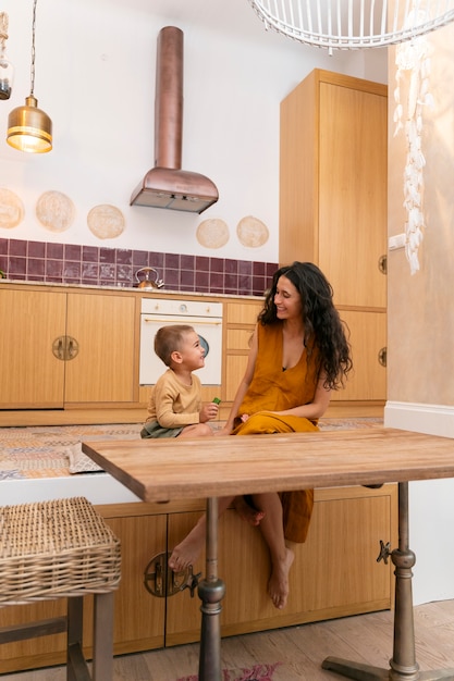 Full shot smiley woman and kid indoors