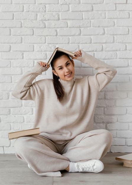 Full shot smiley woman with book on head