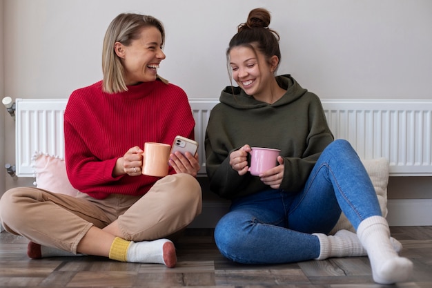 コーヒーカップとフルショットのスマイリー女性