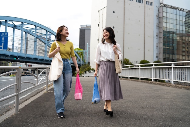 Foto donne sorridenti a tutto campo con borse di tela