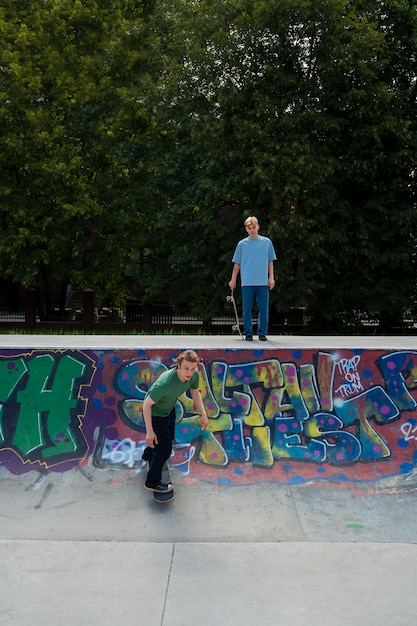 Foto full shot tieners met skateboards buiten