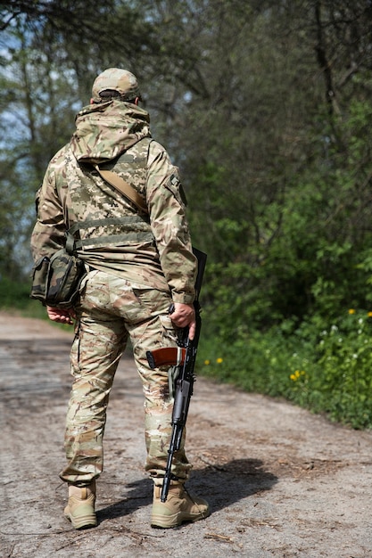 Foto soldato ucraino del colpo pieno che tiene la pistola