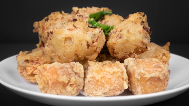 Full shot variation of indonesian fritters in a black background