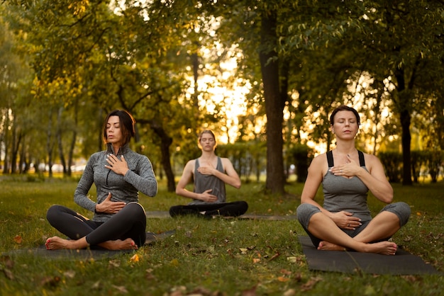 Foto full shot vrouwen mediteren op yogamatten