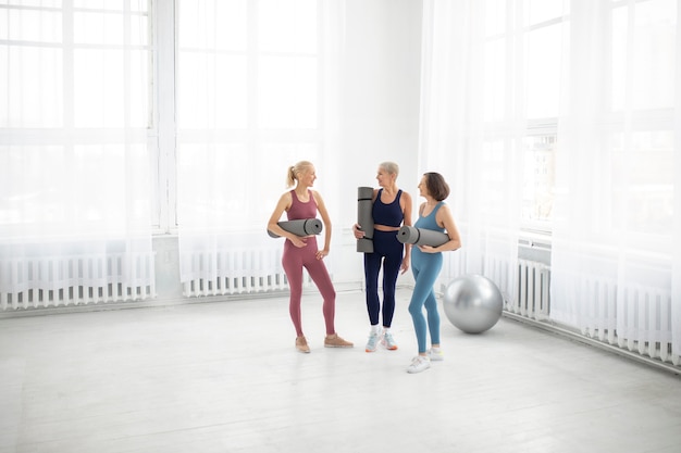 Foto full shot vrouwen met yogamatten