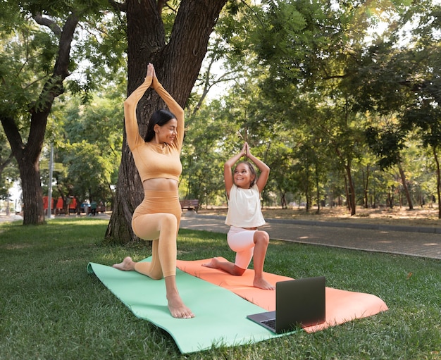 写真 フルショットの女性と女の子が外で瞑想