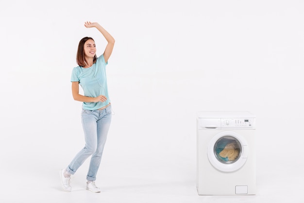 Photo full shot woman dancing near washing machine