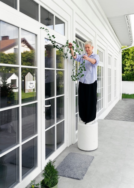 Foto donna a figura intera che decora la porta d'ingresso all'esterno