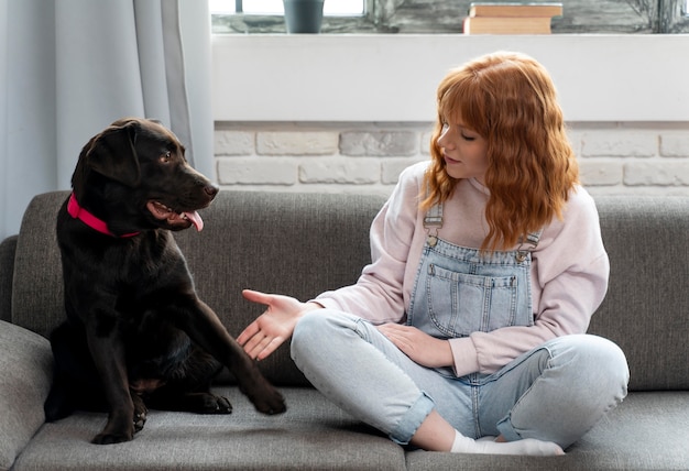 Full shot woman and dog on couch