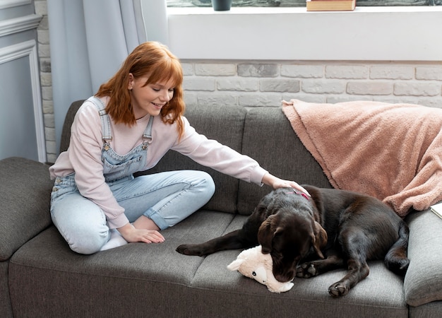 フルショットの女性とソファの上の犬