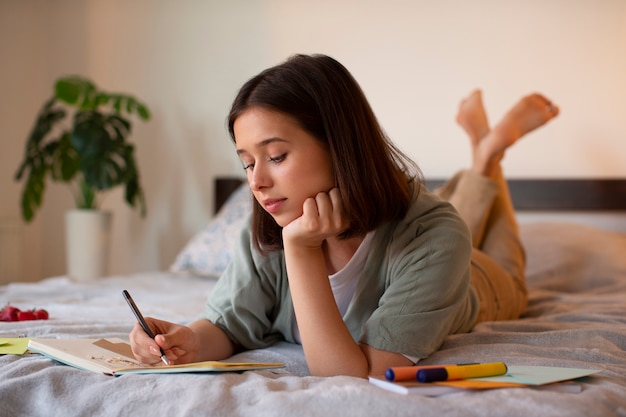 Full shot woman doing creative journaling