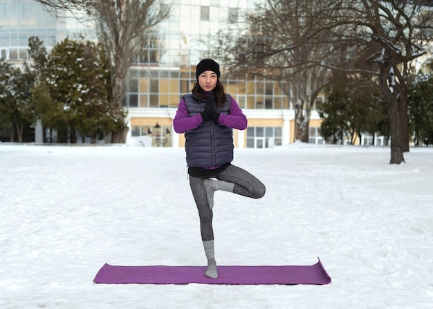 Photo full shot woman doing yoga in cold weather