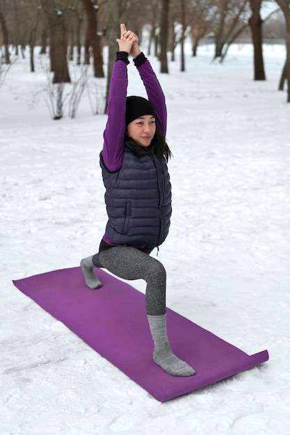 写真 寒い季節にヨガをしているフルショットの女性