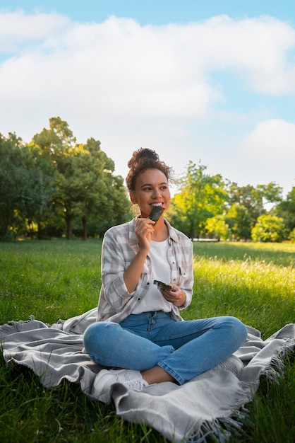 full shot woman  eating seaweed snack