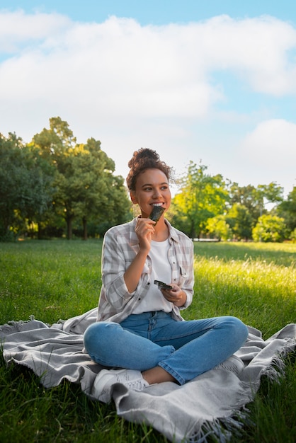 Full shot woman  eating seaweed snack