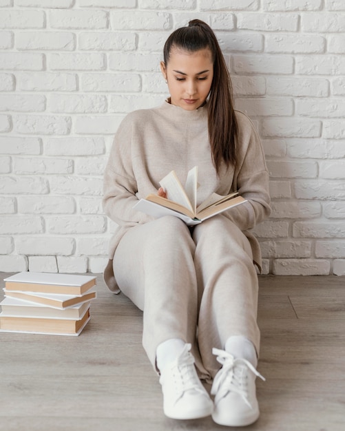 Photo full shot woman on floor reading