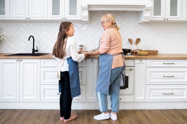 Foto donna a tutto campo e nonna in cucina