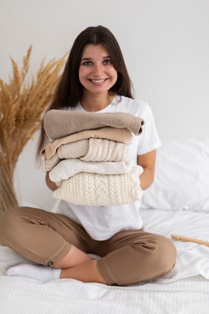 Foto donna a tutto campo che tiene i vestiti