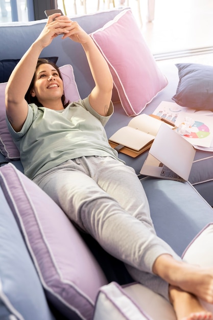 Full shot woman laying on couch