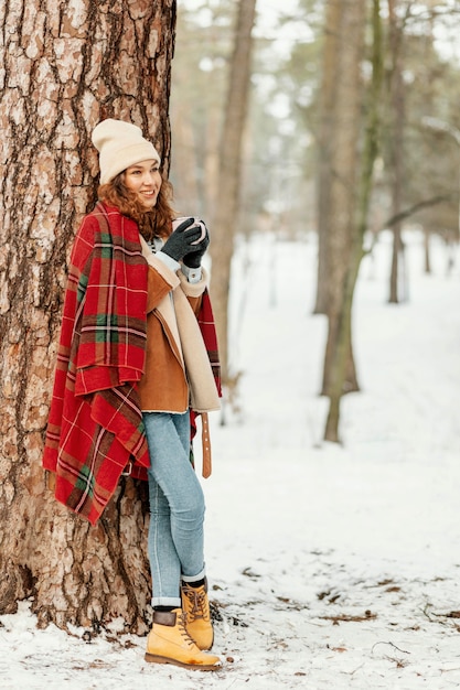 写真 木に寄りかかってフルショットの女性