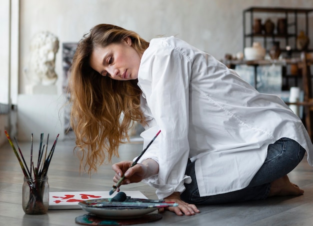 Foto pittura della donna del colpo pieno sul pavimento