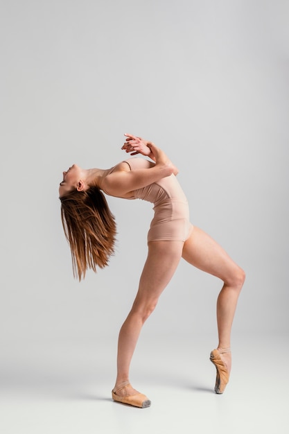 full shot woman performing  in pointe shoes