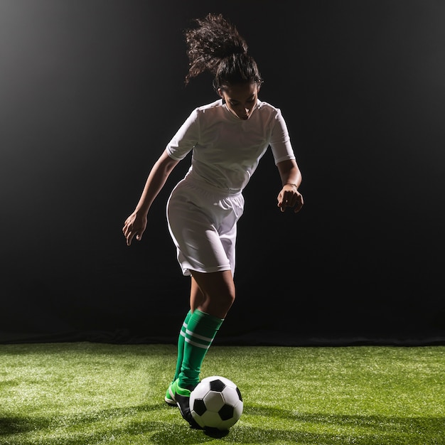 Foto giocar a calcioe della donna della foto a figura intera