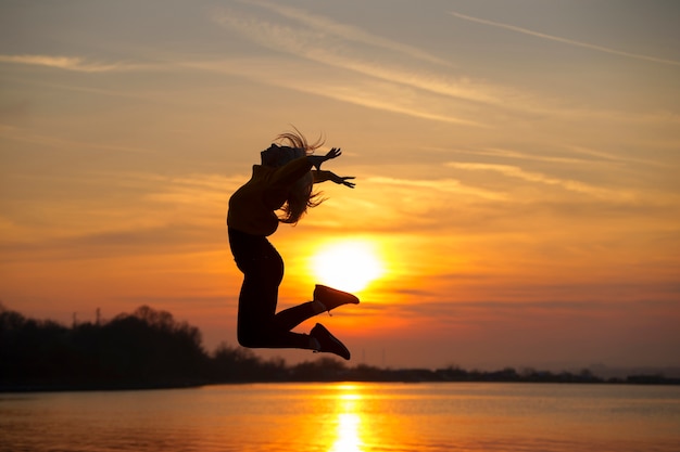 Foto donna del colpo pieno che posa al tramonto