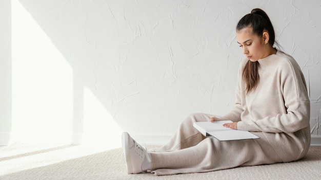 Photo full shot woman reading book  on floor