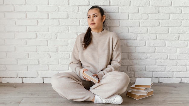 Full shot woman sitting on floor