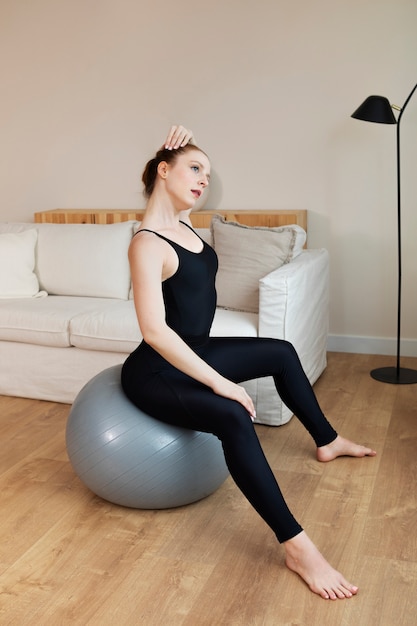 Photo full shot woman sitting on gym ball