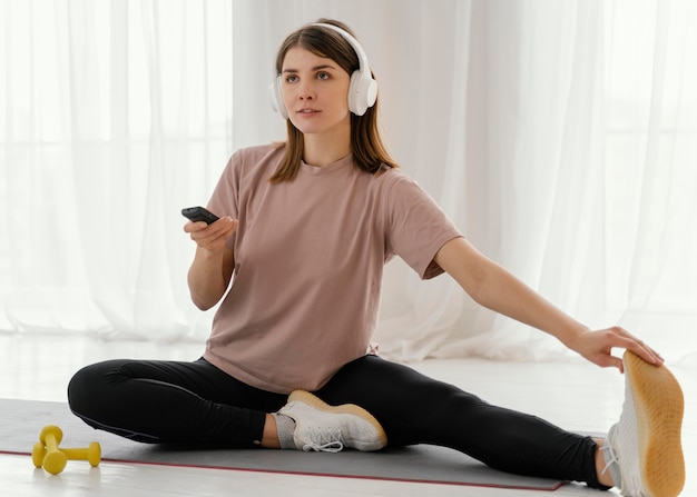 Full shot woman stretching leg