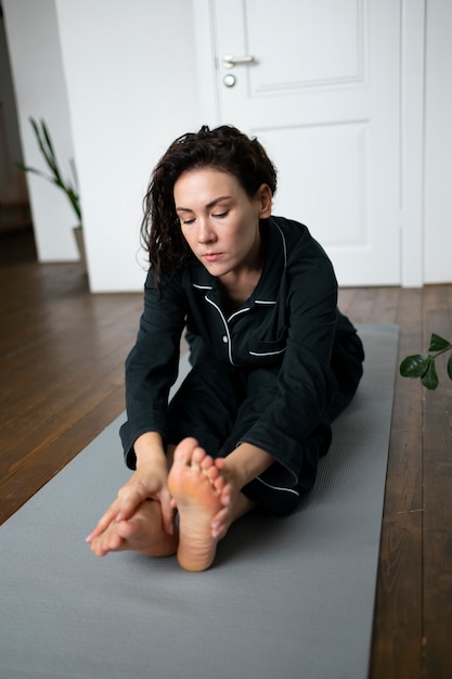 Photo full shot woman stretching on mat