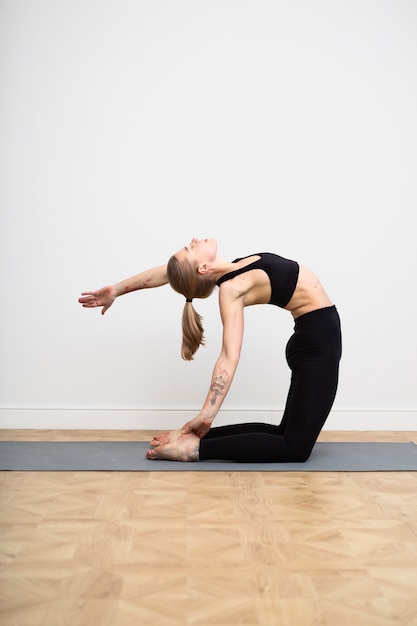 Full shot woman stretching on mat