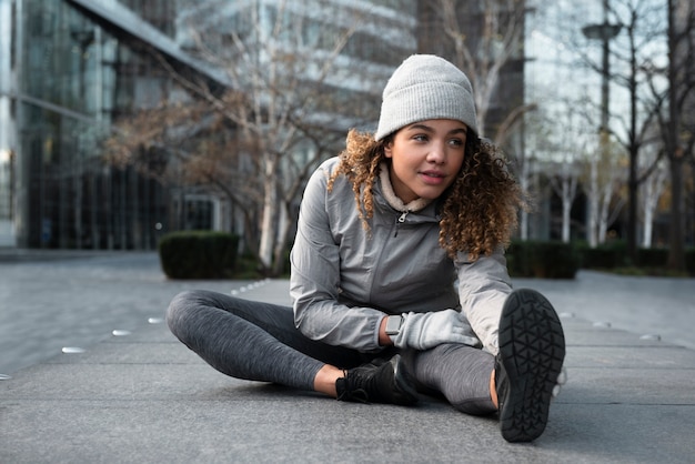 full shot woman stretching outdoors