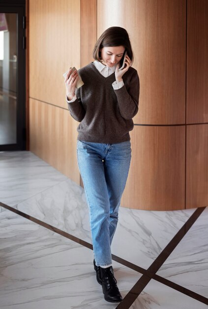 Foto donna della foto a figura intera che parla sul telefono